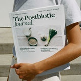 A person holding a printed copy of The Postbiotic Journal