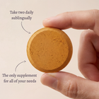 Woman taking an AYA BIOME PURE fermented turmeric chewable tablet