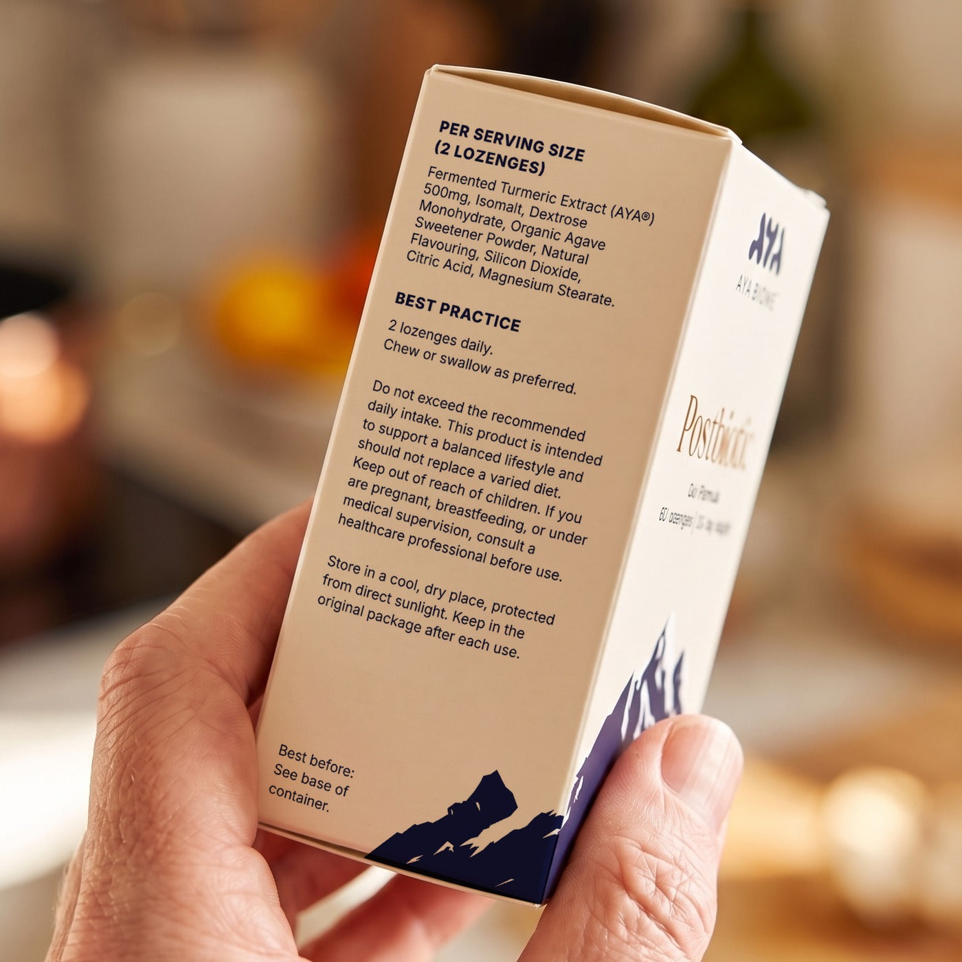 A hand holding an AYA BIOME™ PURE box turned to the ingredients on its side